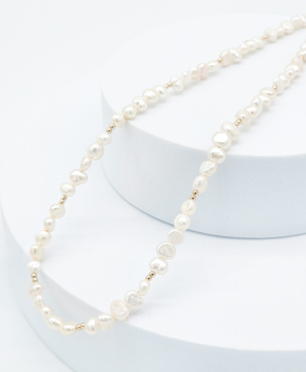 Kaklo vėrinys su nelygiais gėlavandeniais perlais - minimalistinis, neįpareigojantis.