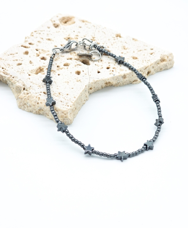 Jaunatviška ir smulki rankų darbo apyrankė su žvaigždutėmis. Hematitas laikomas stiprybės, apsaugos ir vidinės ramybės simboliu. Puiki dovana.